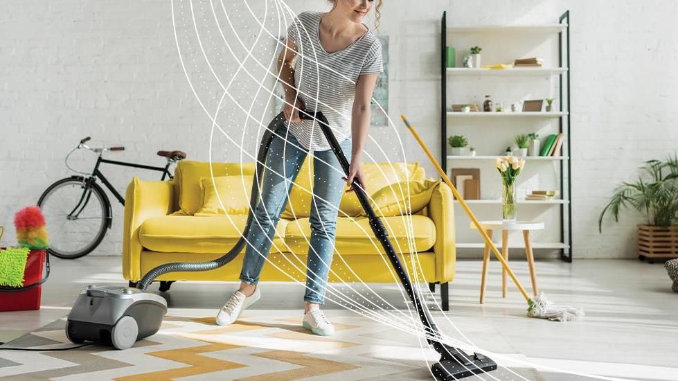 person using modern vacuum on rug in bright room