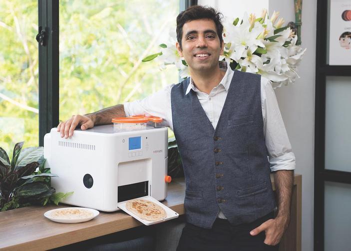 Rishi Israni standing next to his Rotimatic Roti-making machine