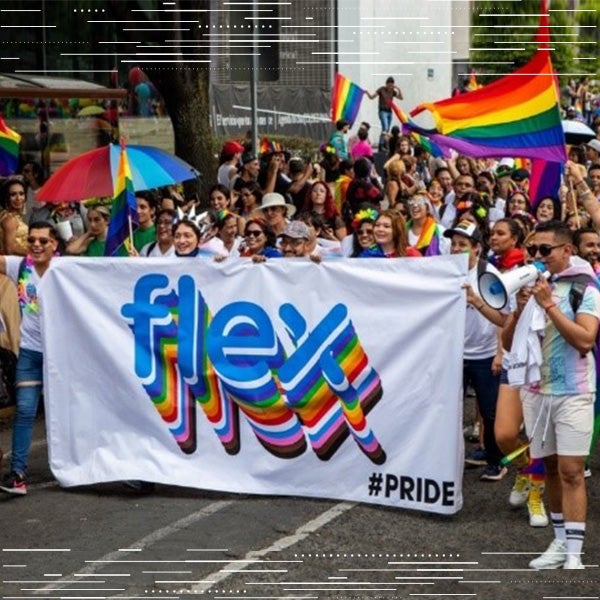 Flex-Mitarbeiter versammeln sich draußen, um die LGBTQ-Inklusivität mit einem regenbogenfarbenen Flex-Banner zu feiern